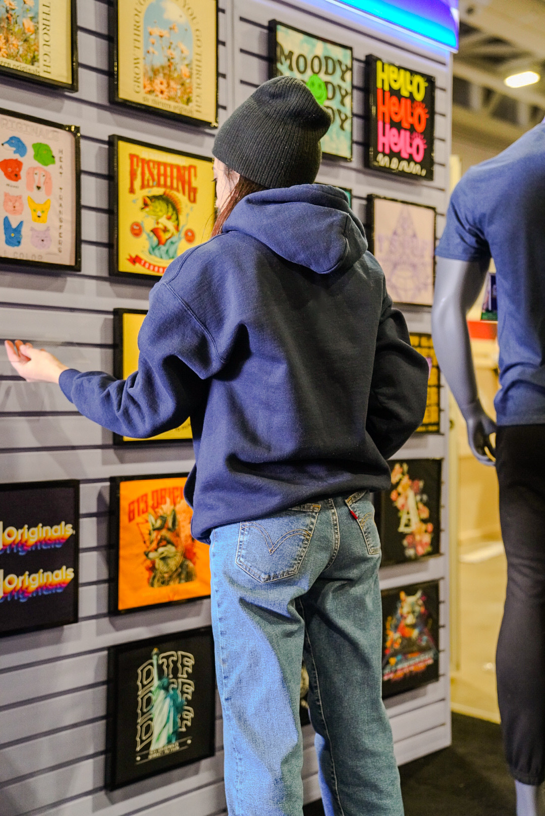 Cat hanging the t-shirt frames on the touch wall.