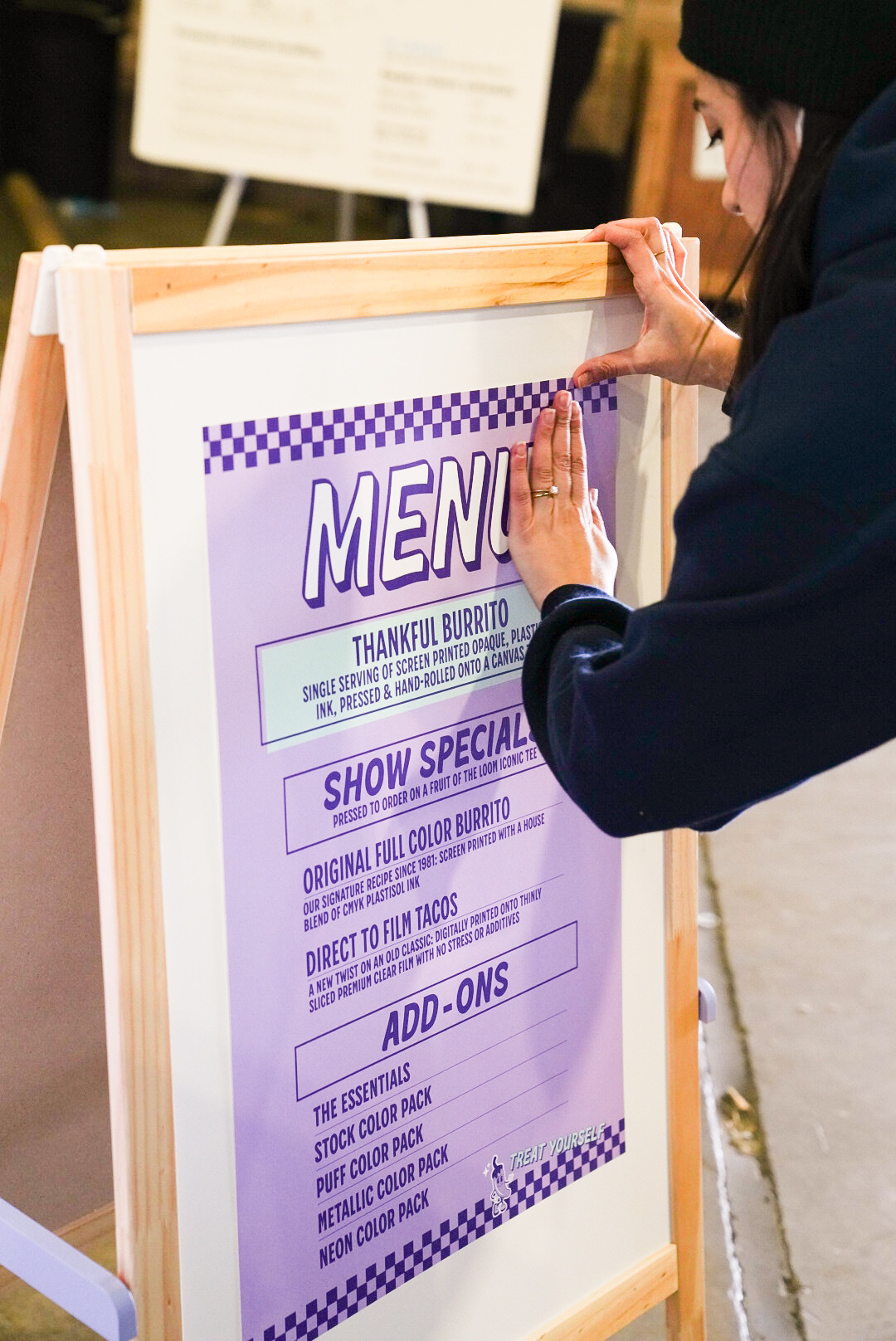 Cat taping the special menu to the menu board.