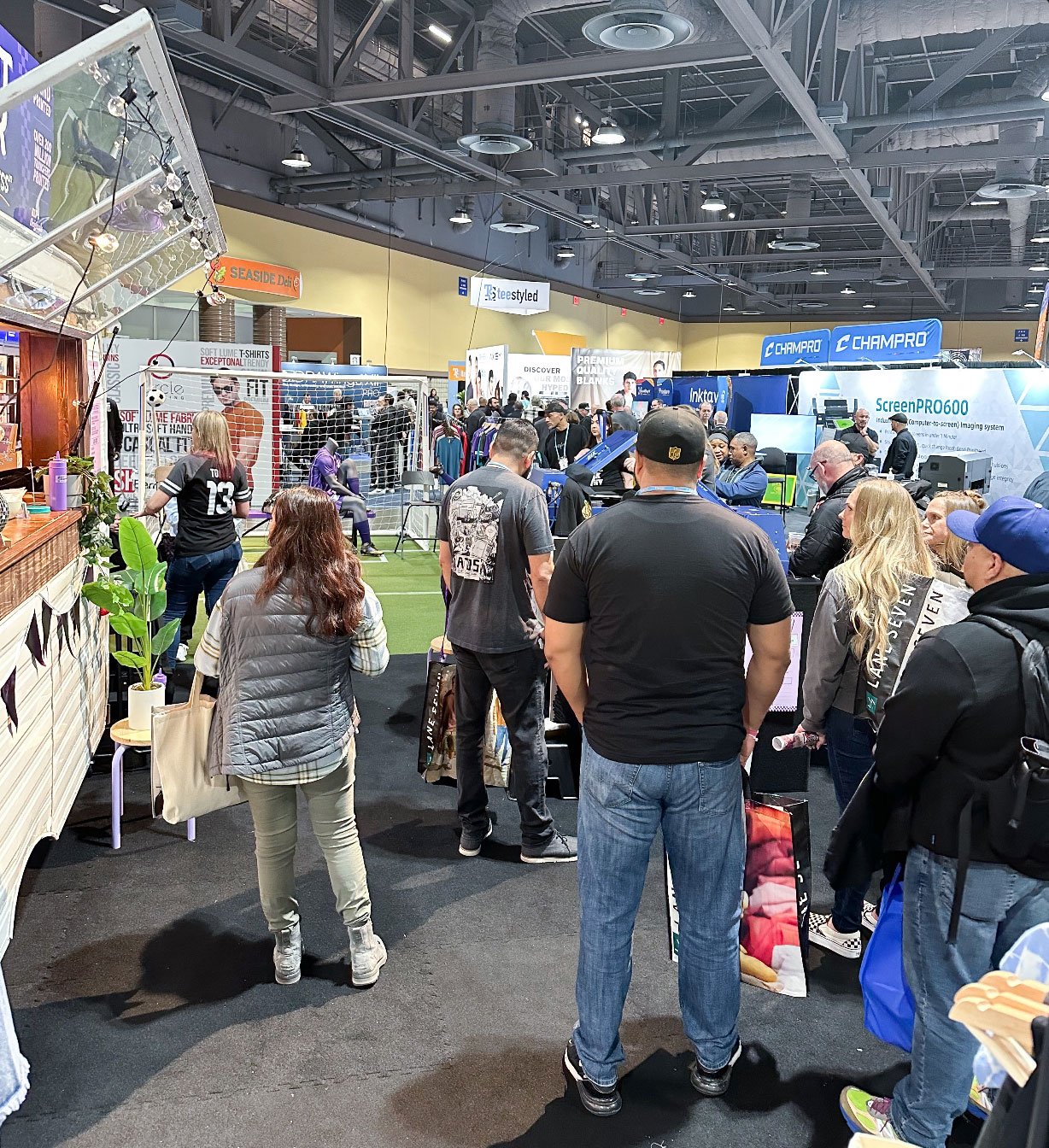 A group of people crowded around the application stations.
