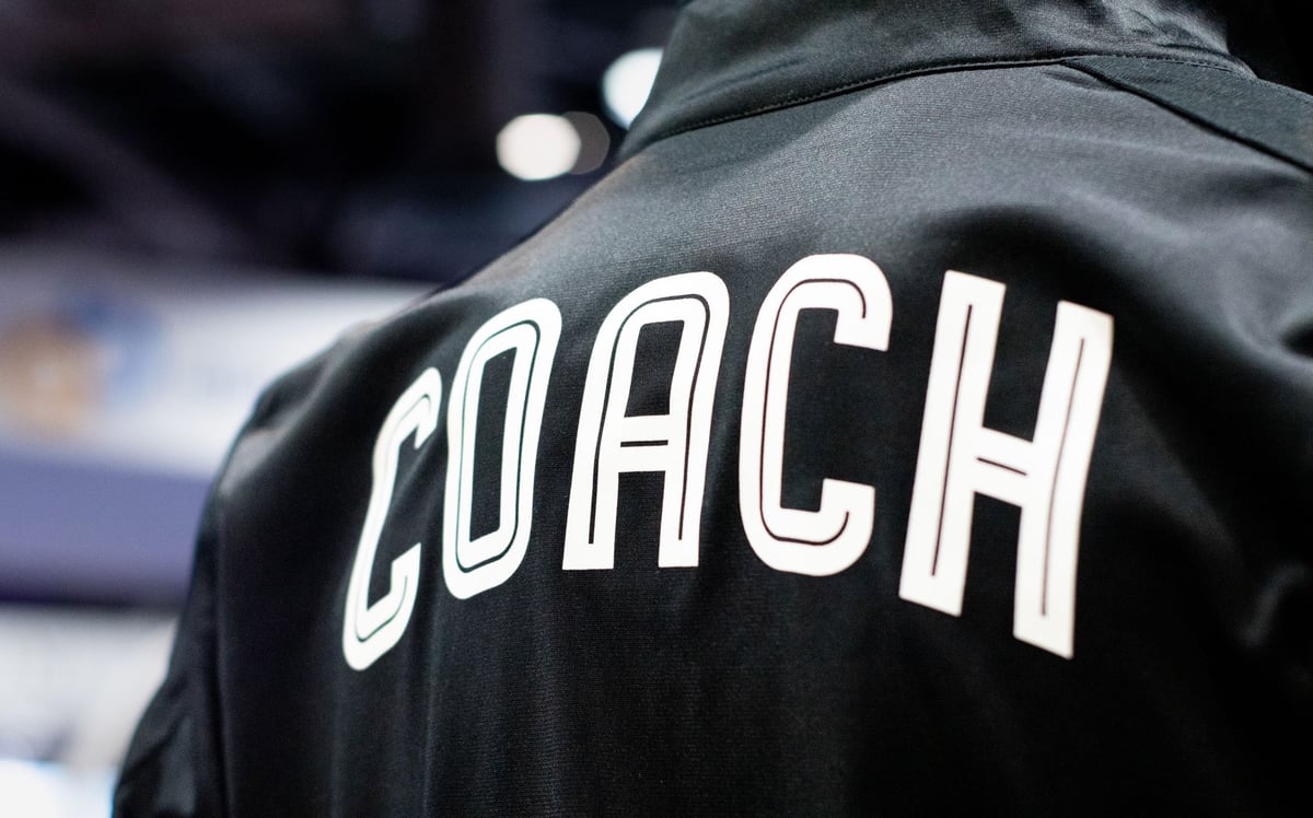 A close up of a black jacket with "COACH" written on the back