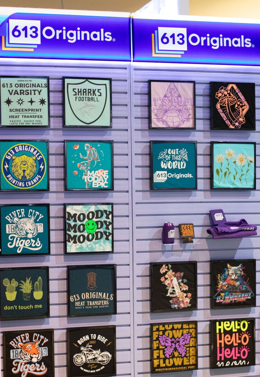 A purple wall with logos on top that read "613 Originals." In the image are various decorated garments.